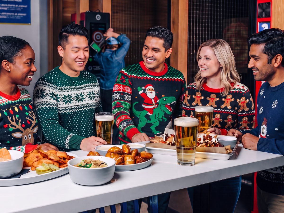 A group in holiday sweaters sharing beers and appetizers at an office party